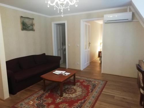 a living room with a black couch and a table at Batthyány Kastélyszálló in Zalacsány