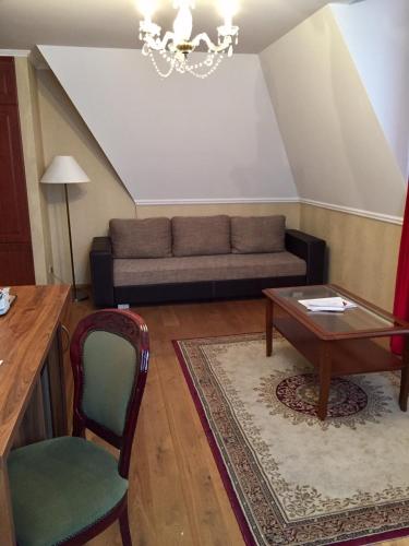 a living room with a couch and a table at Batthyány Kastélyszálló in Zalacsány