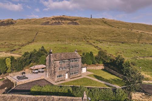 an aerial view of a house on a hill at Rye Top Farm in Saddleworth