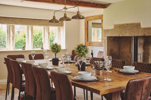 a dining room with a long wooden table and chairs at Rye Top Farm in Saddleworth