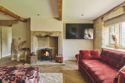 a living room with a red couch and a fireplace at Rye Top Farm in Saddleworth