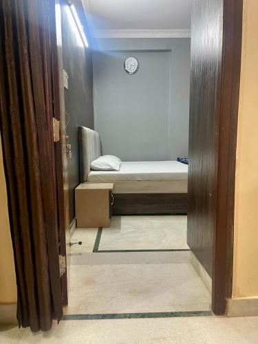 a room with a bed and a clock on the wall at Prince Castle-4BHK Apartment,Guesthouse in Hyderabad