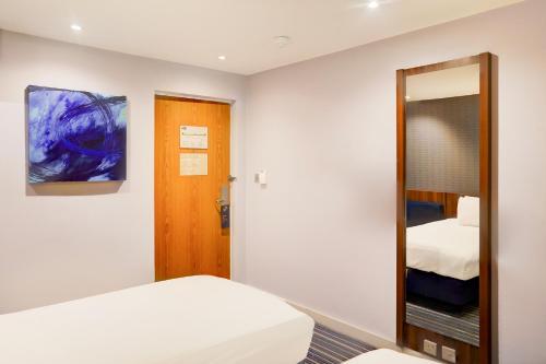 a bedroom with a bed and a mirror at Belvilla Crewe City Centre Lifestyle in Crewe