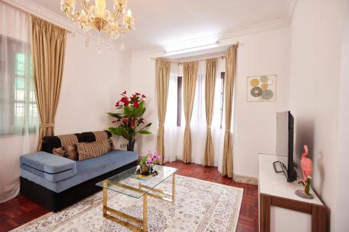 a living room with a blue couch and a tv at Apartment at KTM in Bālāju