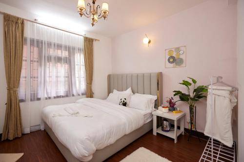 a bedroom with a large white bed and a window at Apartment at KTM in Bālāju