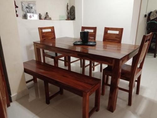 une table et des chaises en bois avec une table et des bancs dans l'établissement Madhur Cottage Homestay, à Mukteswar