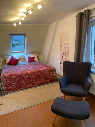 HeeßenにあるFerienwohnung Schwalbennest in Heeßenのベッドと椅子のある寝室