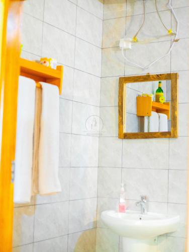 a bathroom with a sink and a mirror at Materuni Homes in Moshi