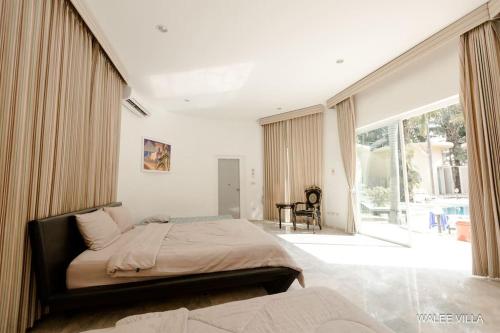 a bedroom with a large bed and a large window at WaleeVilla pattaya in Ban Nong Pla Lai