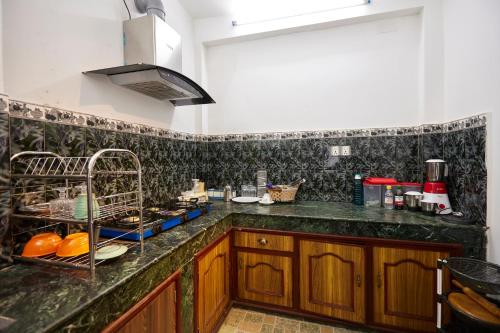 a kitchen with a black and white tiled wall at Apartment at KTM in Bālāju