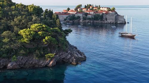 an island with a castle and a boat in the water at Your accommodation in Kotor bays in Kotor