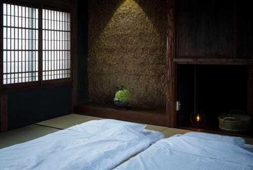 Postel nebo postele na pokoji v ubytování アイショウ 一日ひと組の宿