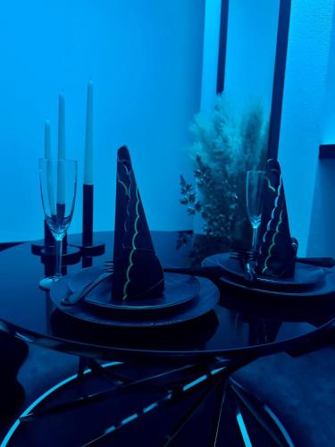 - une table avec deux assiettes et des verres à vin dans l'établissement Studio CHESS, à Mulhouse