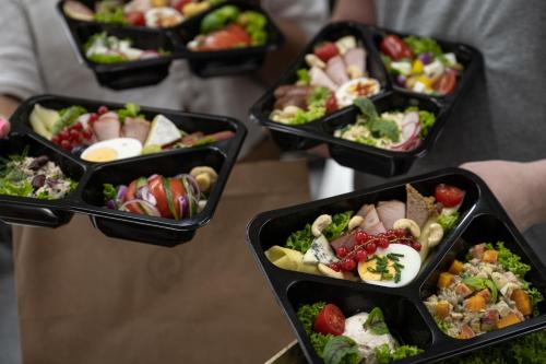 a group of four black containers filled with food at Wierchowa Chata in Kościelisko