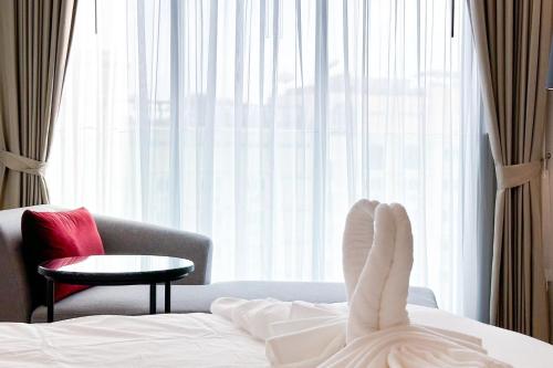a person laying on a bed with their feet in a room at Central Pattaya Condo With Roof Top Pool in Pattaya Central