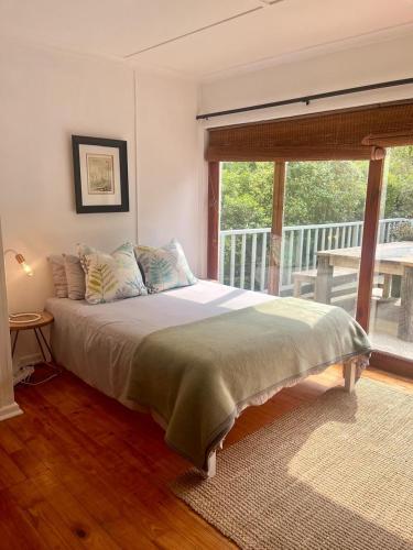a bedroom with a bed and a large window at Paradise View Apartment in Knysna