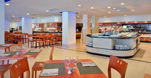 a restaurant with tables and chairs and a bar at Sol Palmanova Mallorca in Palmanova