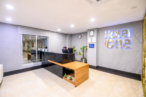 an office with a desk and a hello one sign on the wall at Hotel One Sargodha in Sargodha