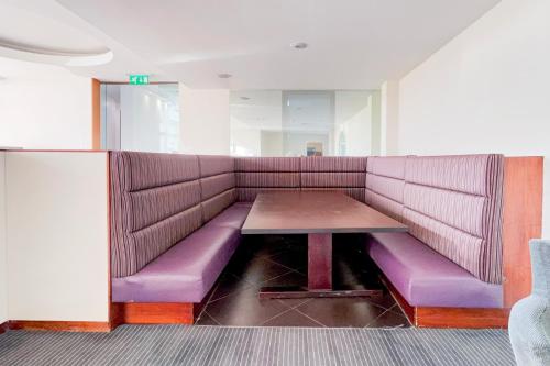 a purple couch with a table in a room at Belvilla Crewe City Centre Lifestyle in Crewe