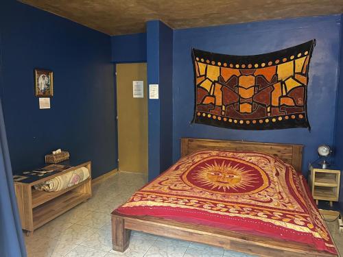 a bedroom with a bed in a room with blue walls at L'Arbre de Vie in Saint-Joseph