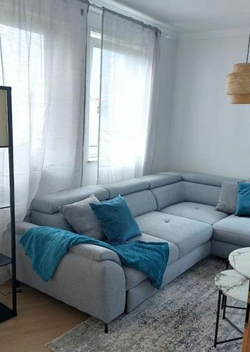 a living room with a gray couch with blue pillows at Ludwigshafen-Bahnhofsresidenz in Ludwigshafen am Rhein