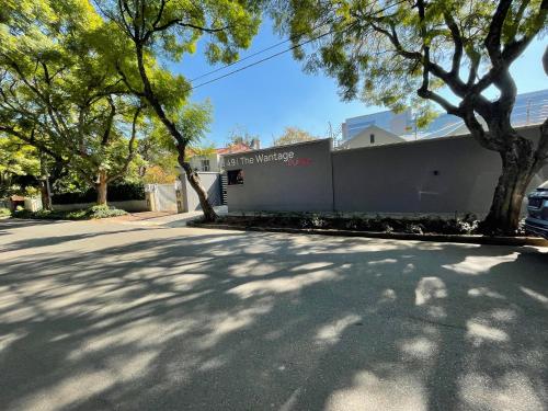 a building on a street with trees in front of it at The Wantage Suites in Johannesburg