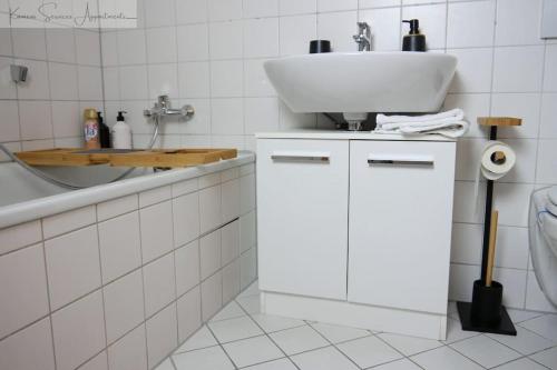 a white bathroom with a sink and a toilet at Ludwigshafen-Bahnhofsresidenz in Ludwigshafen am Rhein