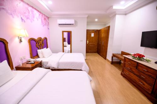 a hotel room with two beds and a flat screen tv at Hotel One Sargodha in Sargodha