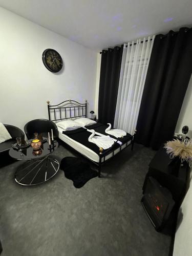- une chambre avec un lit, une chaise et un réveil dans l'établissement Studio CHESS, à Mulhouse