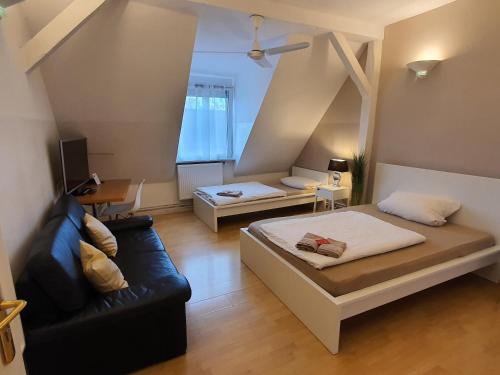 a living room with two beds and a couch at coLodging Mannheim - private rooms & kitchen in Mannheim