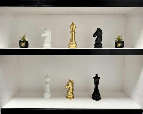 une étagère avec des pièces d'or et d'échecs noirs dans l'établissement Studio CHESS, à Mulhouse