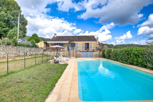 une piscine devant une maison dans l'établissement Villa avec piscine à la campagne, à Tursac