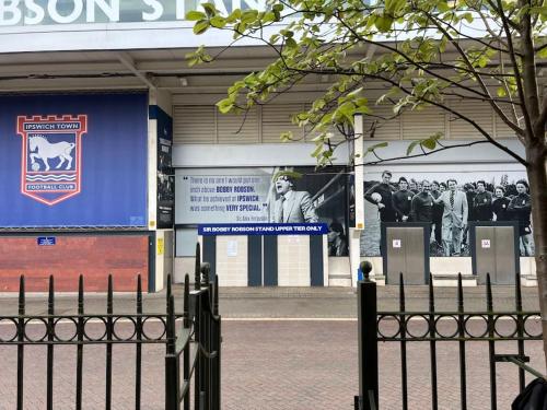 a sign on the side of a building with a fence at 7a Sir Alf Ramsey Way in Ipswich