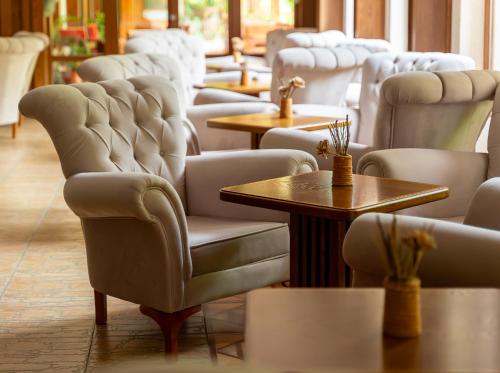 a row of chairs and tables in a room at Hotel Bozhentsi in Chernevtsi