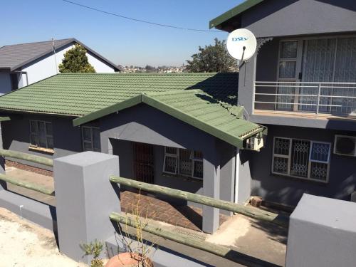 une maison bleue avec un toit vert dans l'établissement KwaMgozimba guest house 1 Room3 or 5, à Durban