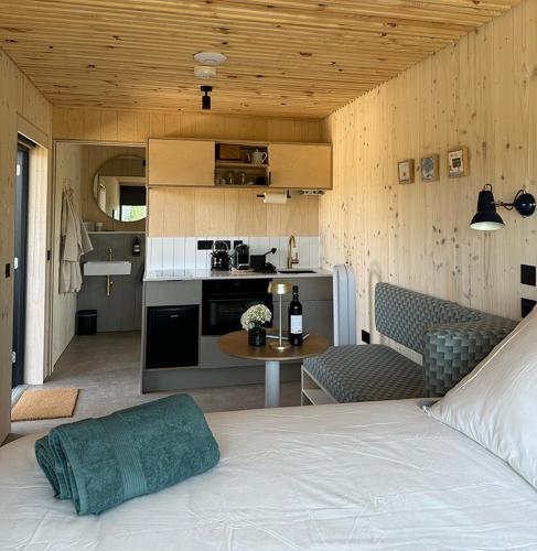 une chambre avec un lit et une cuisine avec une table dans l'établissement Vineyard Cabins at Château Puynard, à Berson