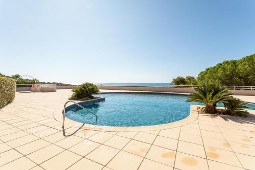 - une piscine sur une terrasse avec l'océan en arrière-plan dans l'établissement Le Domaine du Golf - Appt vue mer avec piscine, à Sète