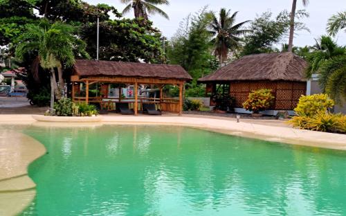 a swimming pool in a resort with a gazebo at Imagine Bohol in Panglao