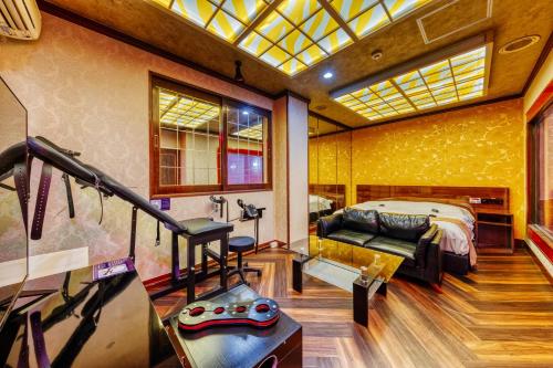 a bedroom with a bed and a couch in a room at HOTEL ABnormal (Adult Only) in Izumiotsu