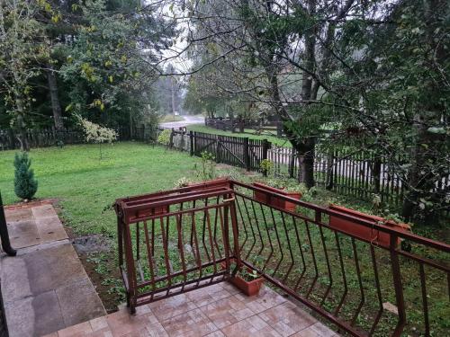 a wooden bench in a yard with a fence at Holiday Home "Iris" near Plitvice Lakes in Rudanovac
