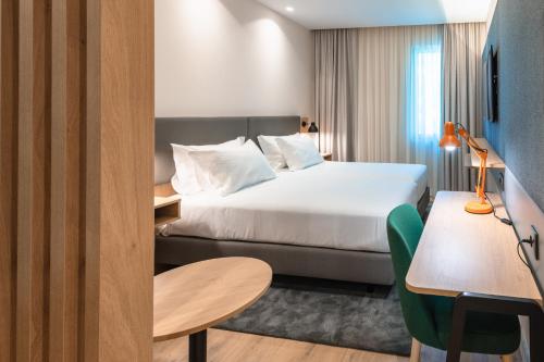 a hotel room with a bed and a table at Holiday Inn Braga by IHG in Braga