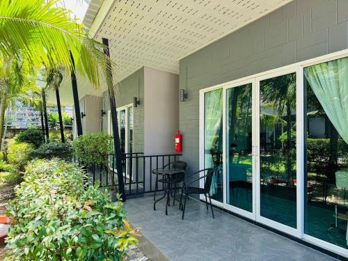 a patio with chairs and a table on a building at Marisa Garden Bungalow in Bang Tao Beach
