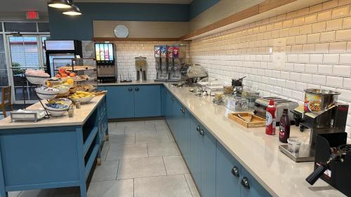 a large kitchen with blue cabinets and a counter top at Country Inn & Suites by Radisson, Austin North Pflugerville , TX in Round Rock