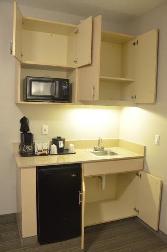 a small kitchen with a sink and a microwave at Country Inn & Suites by Radisson, Austin North Pflugerville , TX in Round Rock
