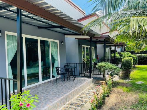 a patio with chairs and tables on a house at Marisa Garden Bungalow in Bang Tao Beach