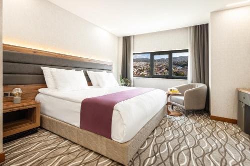 a hotel room with a large bed and a window at Lilium Hotel & Suites in Bursa
