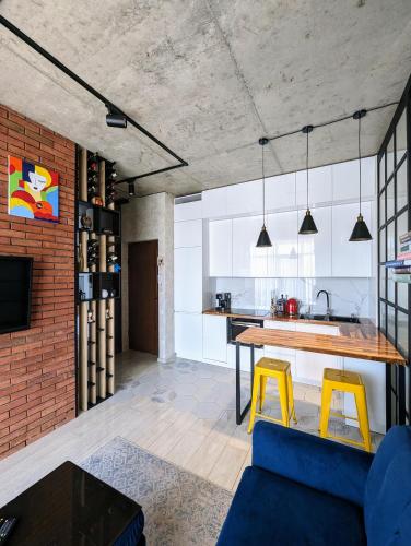 a kitchen and living room with a table and yellow stool at Apartment in bagebi in Tbilisi City