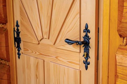 a wooden door with a metal handle on it at Apartamenty Na Brzegu Szczawnica in Szczawnica