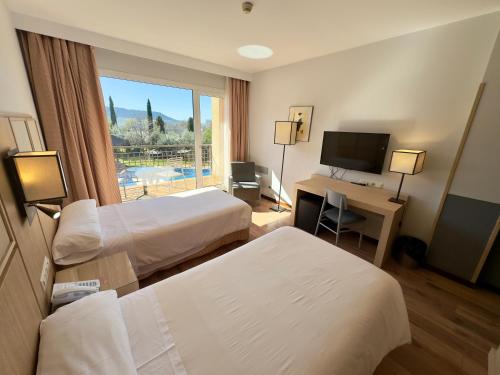 Pokój hotelowy z 2 łóżkami i biurkiem z komputerem w obiekcie Hotel Isla de La Garena w mieście Alcalá de Henares