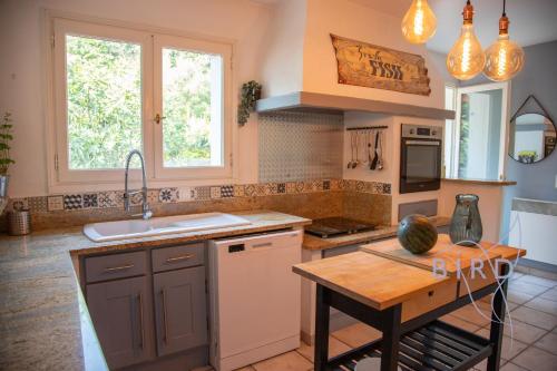 a kitchen with a sink and a counter with a table at Charming Provencal house in the heart of the Fayence region in Tourrettes